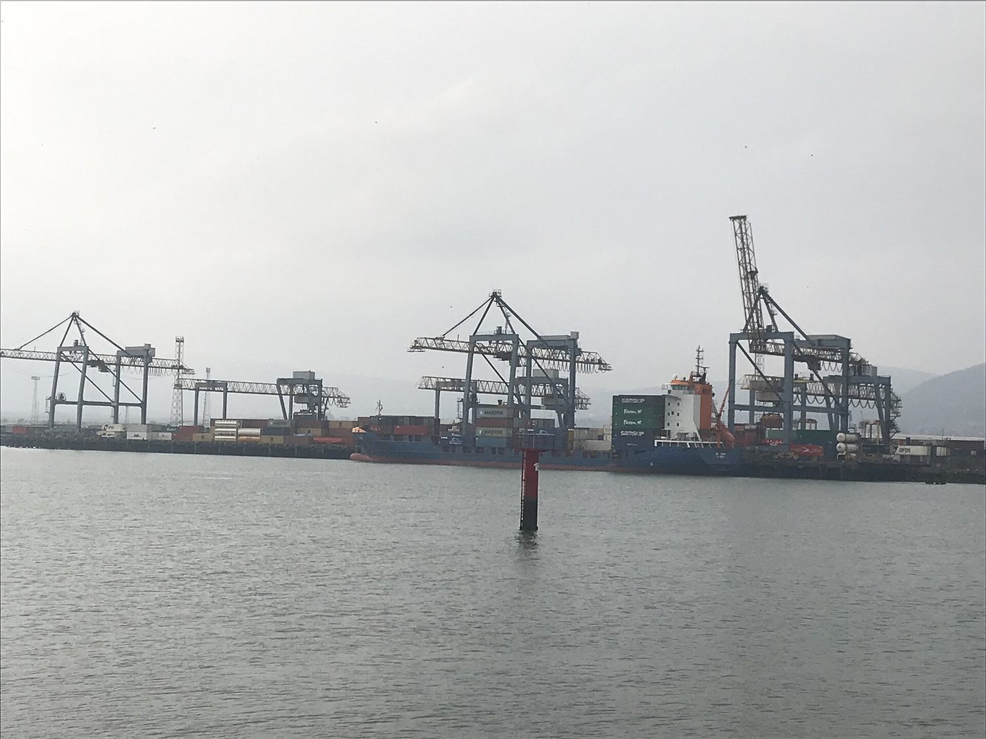 Gantry cranes working over stacked shipping containers at a container terminal